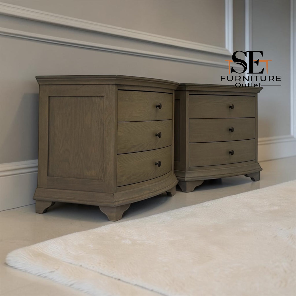 Two matching gray-brown wooden nightstands with three drawers and dark knobs, shown in a styled room setting with a white rug and gray wall molding. An 'SE FURNITURE OUTLET' logo is visible in the top right.

