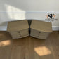 A pair of light beige curved nightstands with three drawers each, placed on a wooden floor against a white wall. The SE Furniture Outlet logo is visible in the top right corner.

