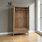 A light oak wood double wardrobe with one door open, showing the interior shelving and glass side panels. The wardrobe is set in a room with light wood floors, a gray wall, and a window on the right.


