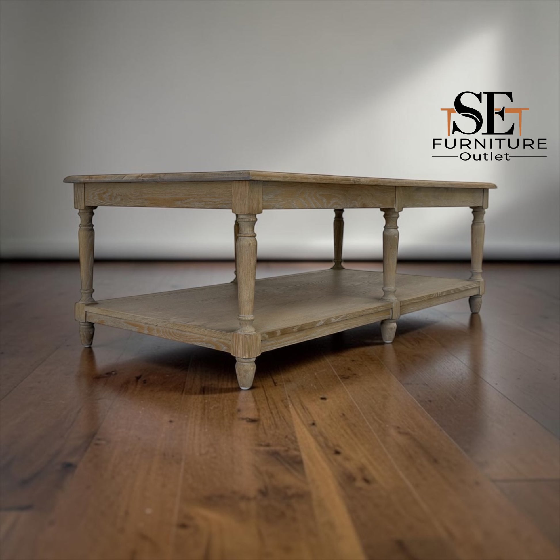 Wooden table with a shelf on a wooden floor, branded 'SE Furniture Outlet'.

