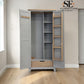 A tall gray wardrobe with open doors, showing light wood interior shelves, a hanging rod, and a drawer at the bottom, photographed in a room with light wood flooring. A 'SE Furniture Outlet' logo appears in the top right.

