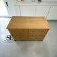 A light oak wood chest of drawers with six drawers and small silver knobs, photographed in a modern kitchen setting. A 'SET FURNITURE Outlet' logo is visible in the bottom-left corner.

