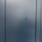 A close-up of a matte dark gray or slate-blue door panel with vertical seam lines.

