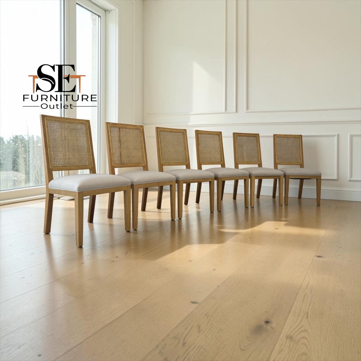 A row of eight dining chairs with light oak wood frames, woven cane backs, and cream upholstered seats, arranged on a light wood floor in a bright room with white paneled walls.

